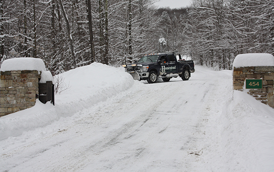 Photo of a truck snowplowing a driveway
