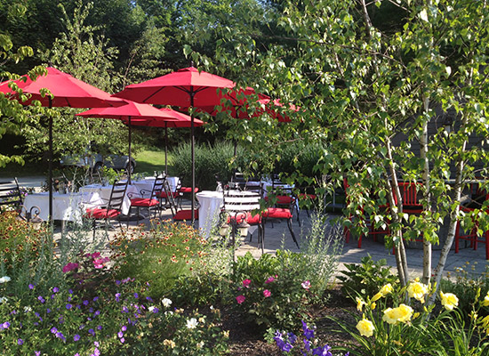 Picture of flower gardens for a resturant patio with red umbrellas